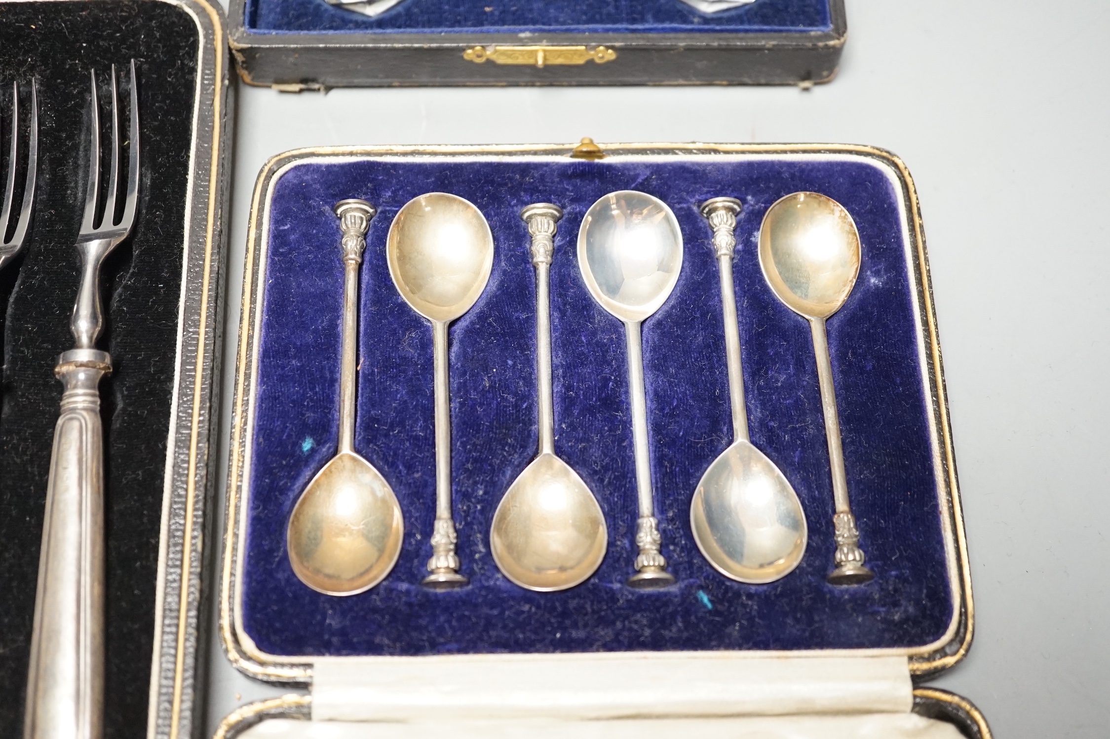 Two 18th century silver 'berry' spoons in associated case and three other cased sets including, pair of silver mounted glass knife rests, a cased set of six seal top coffee spoons and a part set of dessert eaters.